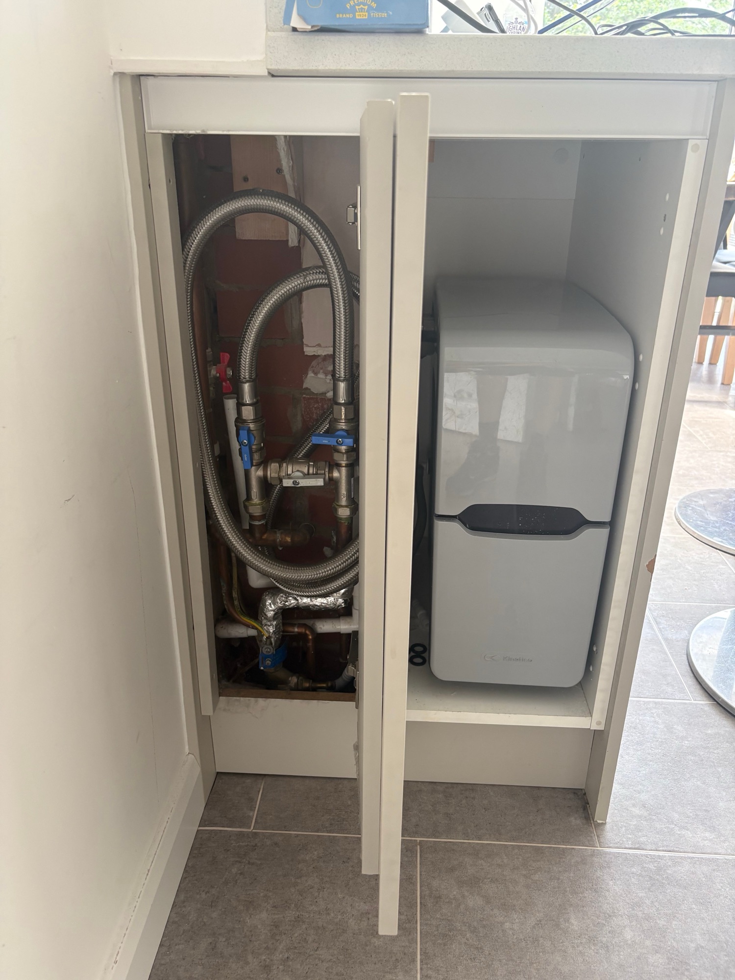 Water softener fitted with new pipework in a kitchen cabinet